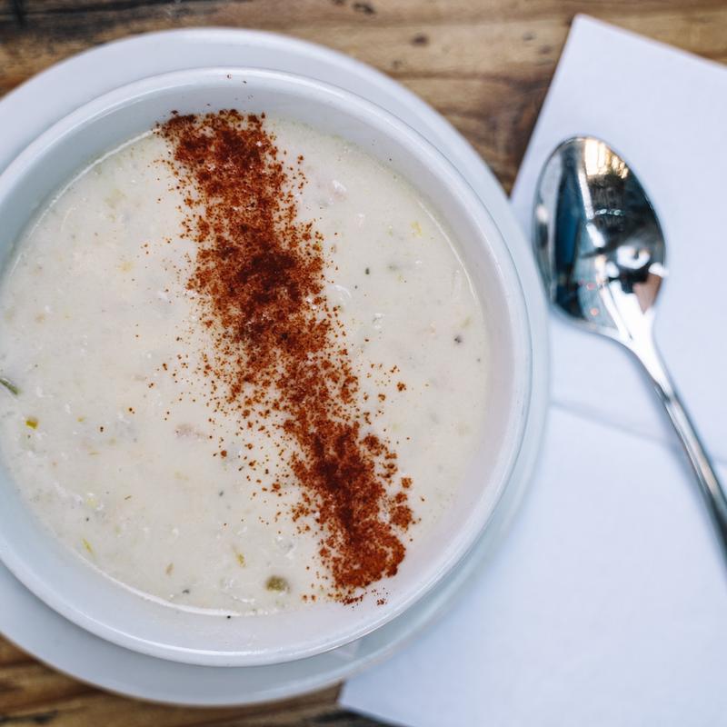 A bowl of clam chowder dusted with paprika