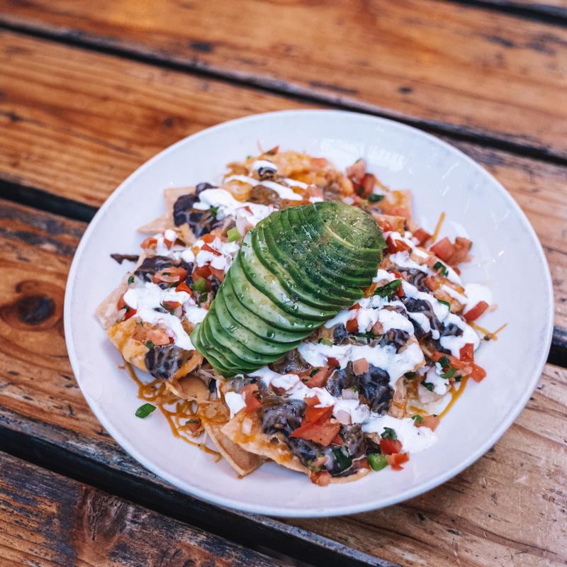 Joey's nachos topped with avocado and crema