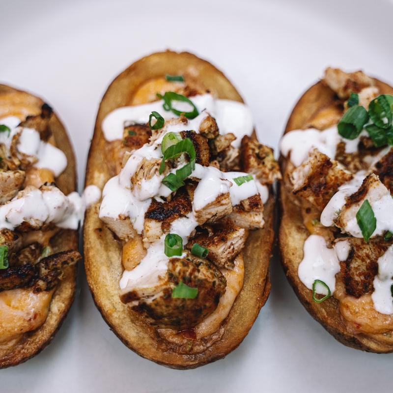 Blackened chicken potato skins topped with crema and scallions