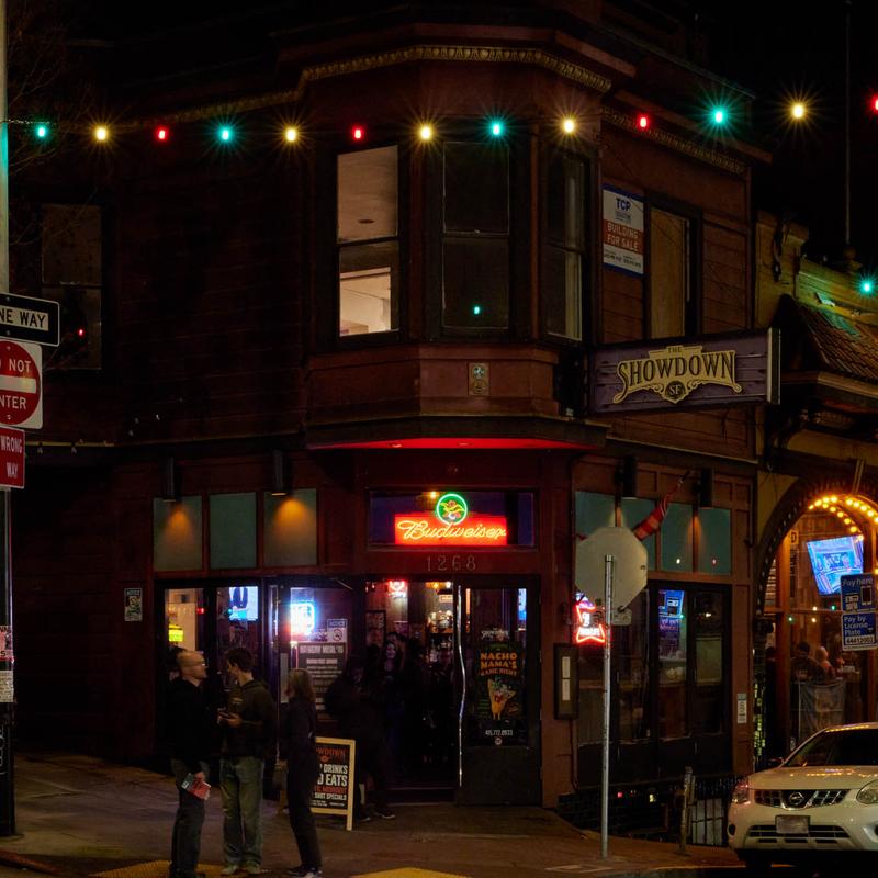 The Showdown's corner storefront at night under string lights