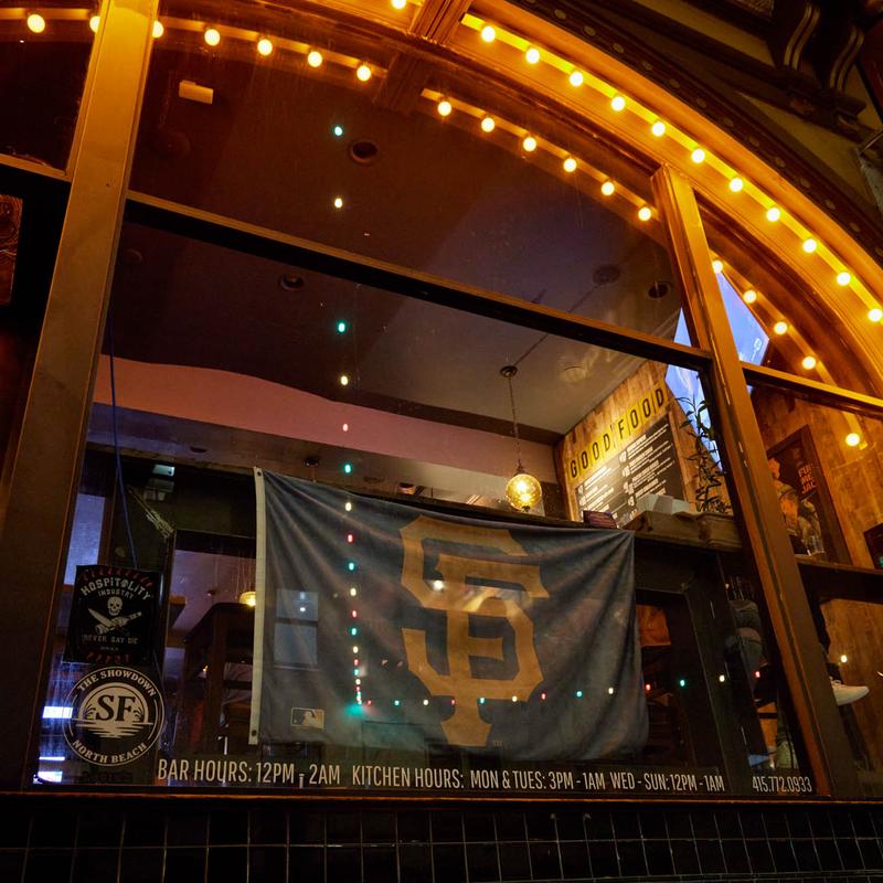 A Giants flag hanging in the front window under marquee lights