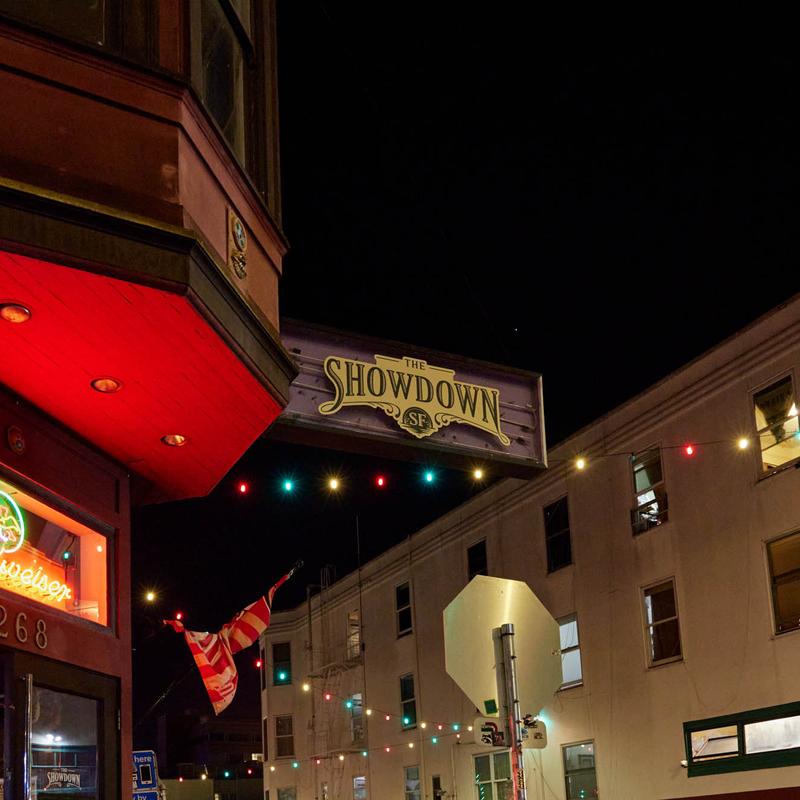 The Showdown sign and string lights over Grant Ave at night