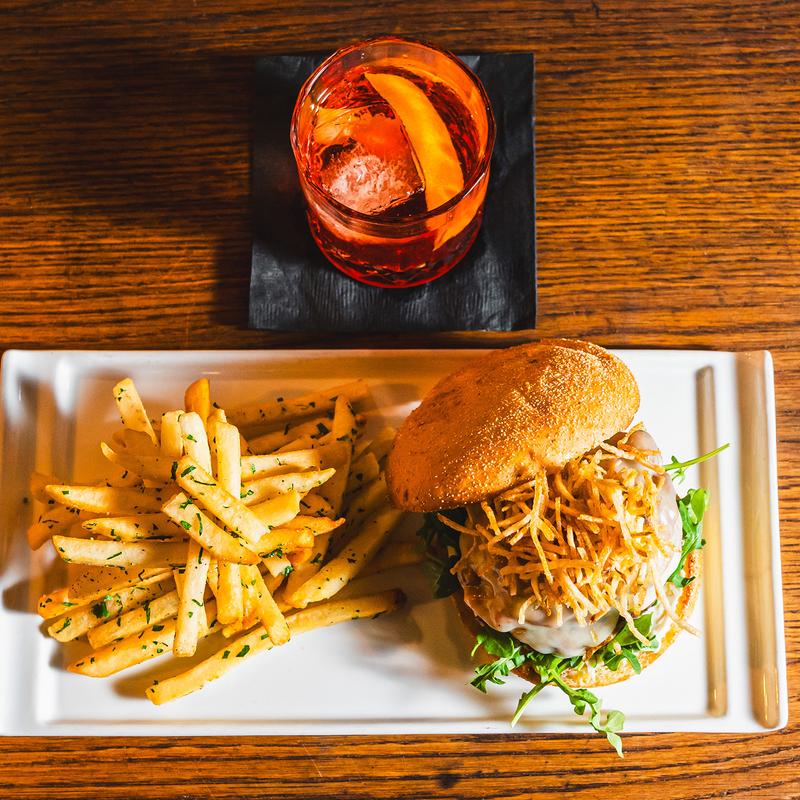 Burger served with fries and a cocktail, top view