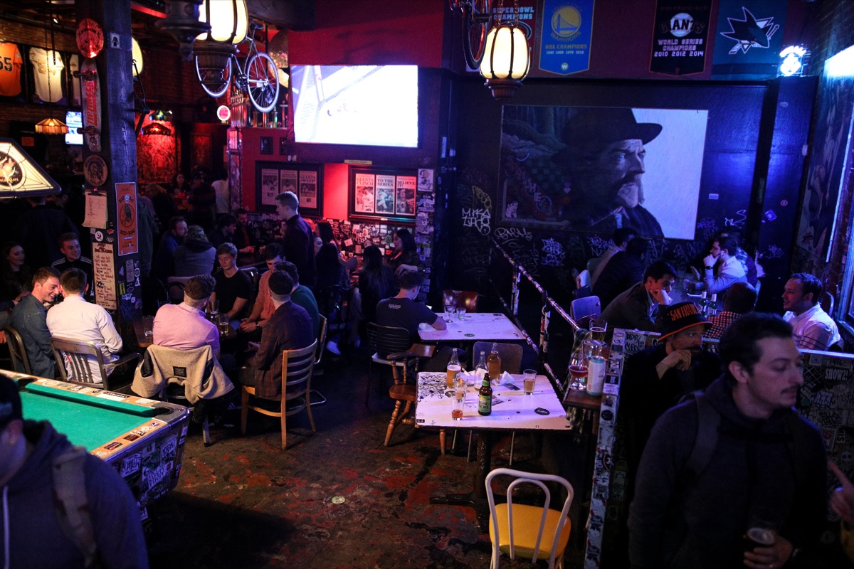 The back room with the pool table, tables of guests, and a projector screen